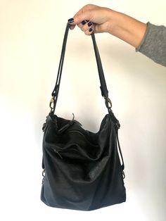 "The Donos Convertible bag - backpack in one simple movement has arrived! Beautiful shoulder bag, easily converted into a useful backpack (no need to make any arrangement in the handles), made in a gorgeous buttery soft and thick black leather. It's quite big, it can fit many things, the bag will adapt very easily to whatever you need to carry, even your 13\" laptop, water bottle, umbrella, wallet, cosmetic bags, etc.. Top zipper to keep it safe. It also has a zippered outside pocket in one side Leather Sling Shoulder Bag For Everyday, Everyday Use Backpack With Double Handle And Soft Leather, Everyday Use Soft Leather Backpack With Double Handle, Soft Leather Backpack With Double Handle For Everyday Use, Versatile Black Backpack With Double Handle, Versatile Everyday Leather Backpack With Zipper Closure, Everyday Versatile Leather Backpack With Zipper Closure, Everyday Versatile Leather Backpack With Zipper, Versatile Soft Leather Satchel Backpack