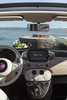 the interior of a small car with an ocean view in the background and text that reads decouvre - la