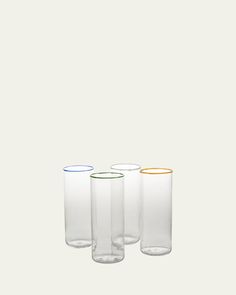 four different colored glass vases sitting next to each other