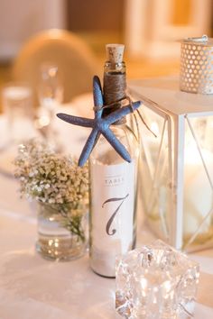 a starfish decoration on top of a table next to a bottle and candle holder