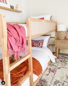 a bedroom with two wooden bunk beds and an area rug on the floor in front of them