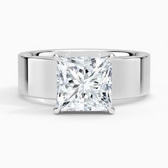 a princess cut diamond engagement ring on a white background, with the center stone visible