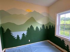 an empty room with mountains painted on the wall