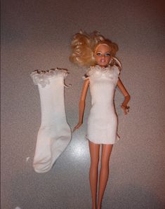 a barbie doll is standing next to two socks