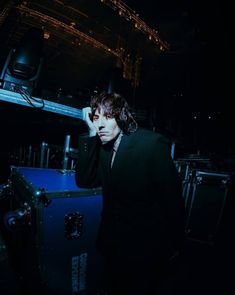 a man standing next to a blue box in the dark