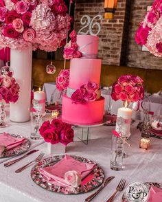 the table is set with pink flowers and candles