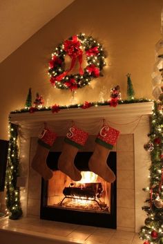 a fireplace decorated with christmas stockings and lights