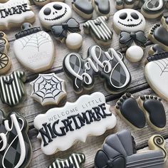 some decorated cookies are sitting on a wooden table with the words welcome little nightmares written in black and white