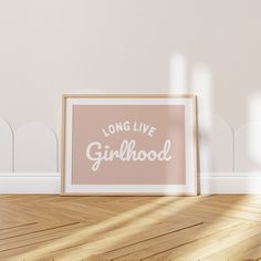 a pink framed poster sitting on top of a wooden floor