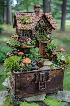 an old suitcase is filled with plants and small houses in the woods, as well as mushrooms