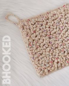 a crocheted bag sitting on top of a white furnishing covered floor