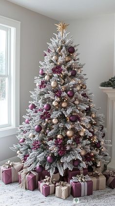 a white christmas tree with purple and gold ornaments