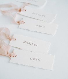 three tags with names on them are tied to the table together and placed next to each other