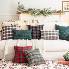 a living room filled with lots of pillows and christmas decorations on top of a white couch