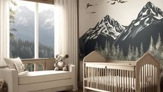 a baby's room with mountains painted on the wall and a crib next to it