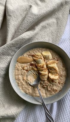 a bowl filled with oatmeal and sliced bananas on top of a white towel