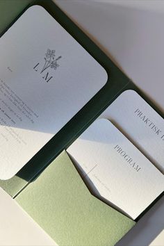 the inside of a green and white wedding card with matching envelopes is displayed on a table