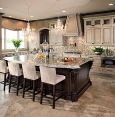 a large kitchen with marble counter tops and white chairs in front of the center island