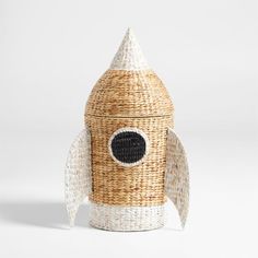 a wicker toy rocket ship with black and white accents