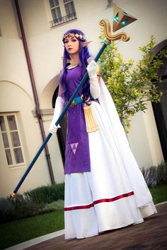 a woman dressed in purple and white holding a staff