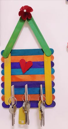 a house made out of popsicle sticks with keys hanging from the side and a red heart on top