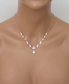 a mannequin wearing a necklace with flowers and pearls on the neck, in front of a white background