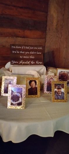 a table topped with pictures and cards on top of a white cloth covered tablecloth