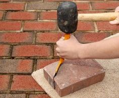 a person is holding an hammer over a block of bricks