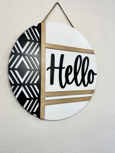 a sign hanging on the wall that says hello written in black and white letters,