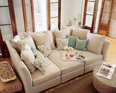 a living room filled with lots of furniture and pillows on top of it's couches