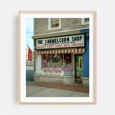 the camellcon shop is located on the corner of an empty street in front of a brick building