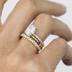 a woman's hand with two rings on it and a diamond in the middle