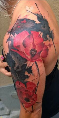 a woman's shoulder with flowers painted on it and the back of her arm