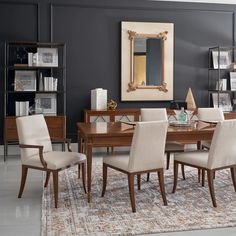 a dining room table with chairs and a mirror on the wall in front of it