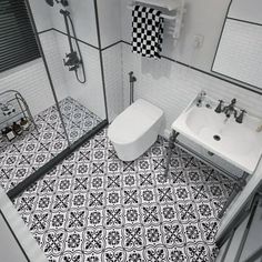 a white toilet sitting next to a sink in a bathroom