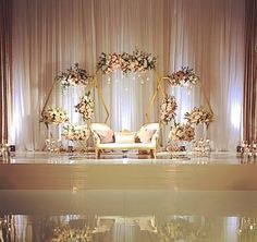 a wedding stage decorated with flowers and greenery