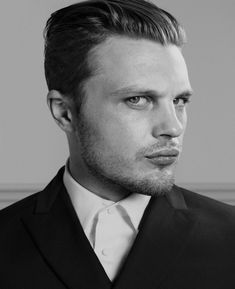 a black and white photo of a man in a suit looking off to the side