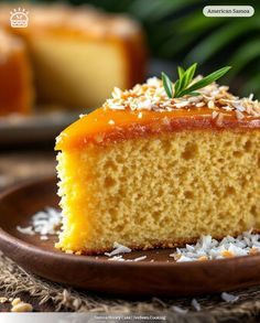 a piece of cake on a plate with coconut sprinkled around the edges and topped with an orange glaze