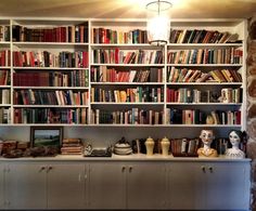 a bookshelf filled with lots of books next to a wall full of shelves