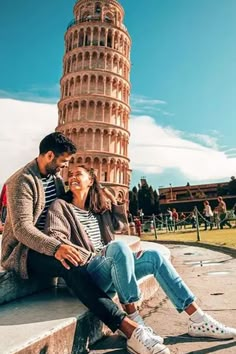 a man and woman sitting next to each other near the leaning tower of pisa, italy