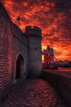 the sun is setting over tower bridge and it's entrance to an old castle