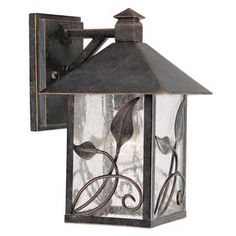 an outdoor wall light with leaves on the front and side panels, in bronze finish