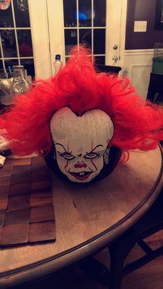 a clown mask sitting on top of a wooden table