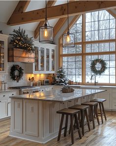 a kitchen filled with lots of counter top space next to a window covered in christmas wreaths