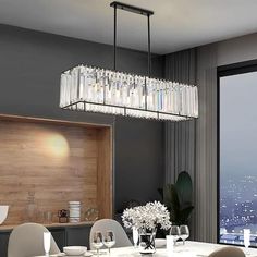 a dining room table with white chairs and a chandelier hanging from the ceiling