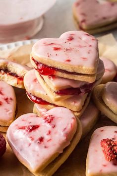 strawberry shortbreads with white frosting and strawberries on top are arranged in the shape of hearts