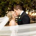 a bride and groom kissing under a veil