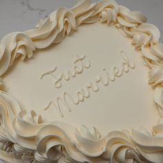 a wedding cake with the words just married carved into it's frosting and icing