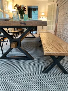 a wooden bench sitting in front of a brick wall next to a dining room table