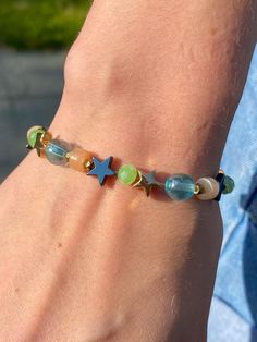 a person wearing a bracelet with beads and stars on it